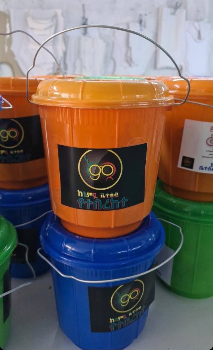 Labelled orange and blue Birqe buckets stacked together.