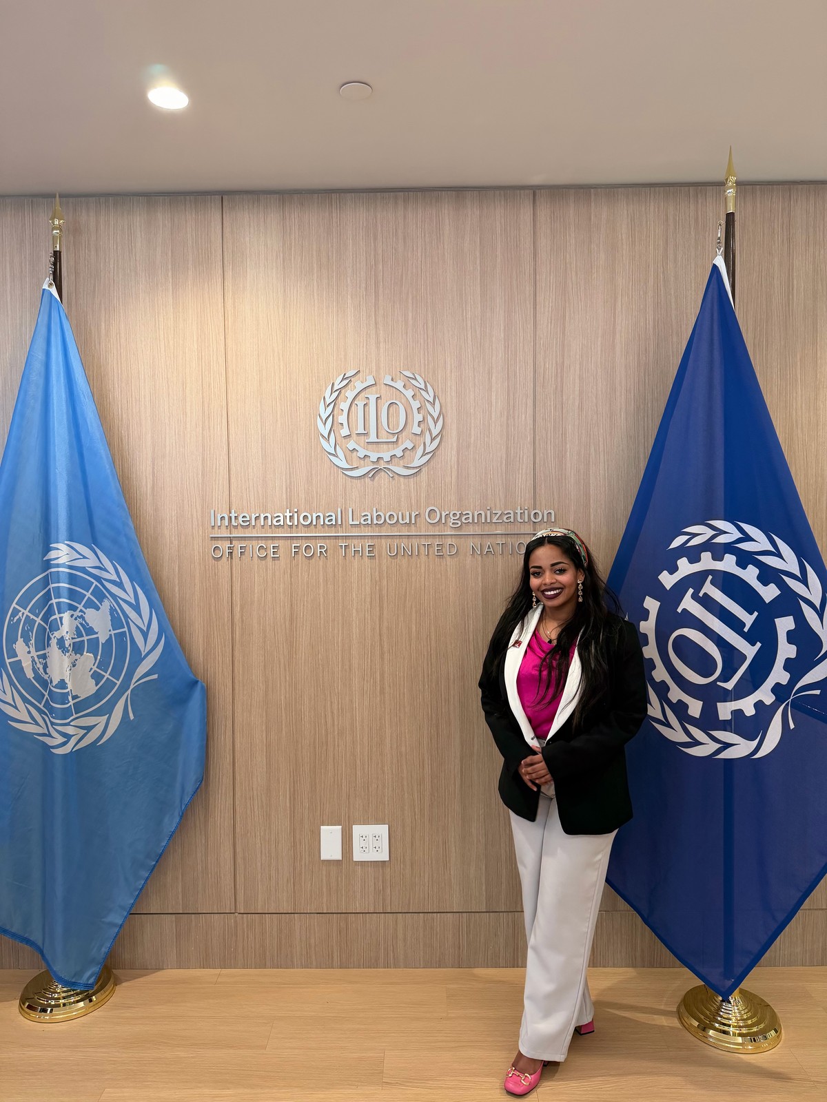 A portrait beside United Nations and International Labour Organization flags.